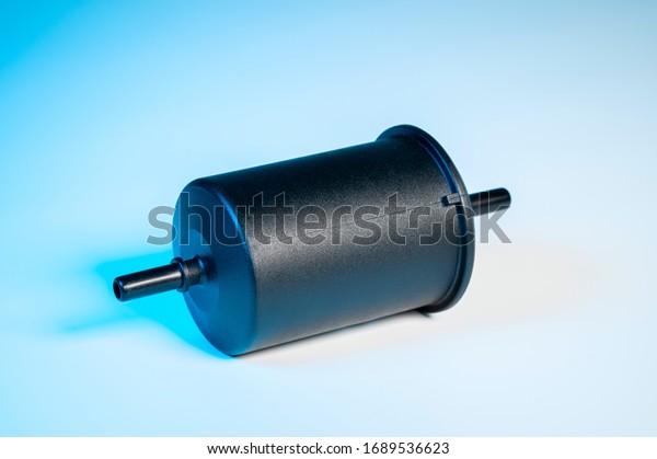 New fuel filter in a black\
plastic housing for diesel and gasoline engines on a gray\
background