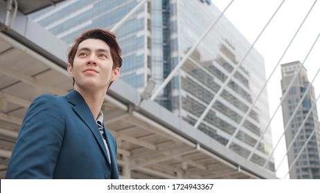 New gen young handsome asian business man wearing suit outdoors in building city background, successful concept, copy space