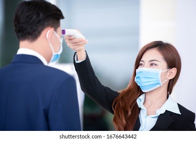 A new generation of Asian businessmen are using a thermometer to measure body temperature after the covid-19 virus has spread to prevent the spread of germs and bacteria. - Powered by Shutterstock