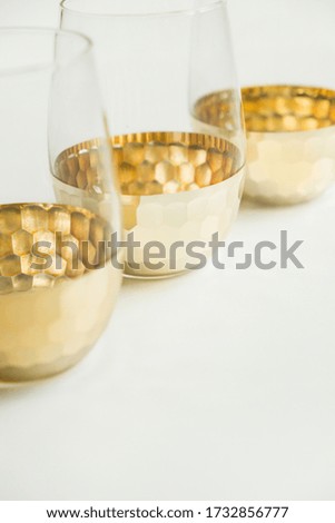New glass with gold bottom on isolated background.