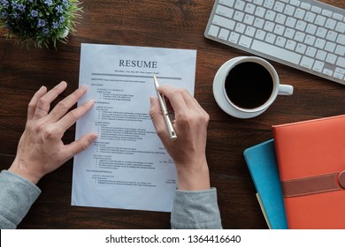 New graduate student holding resume application with pen coffee cup keyboard and notebook for applying for a job. - Shutterstock ID 1364416640