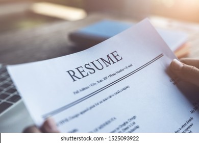 New Graduate Student Holding Resume Application With Pen Coffee Cup Keyboard And Notebook For Applying For A Job.