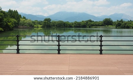 New green leaves and pond and mountains from wood deck