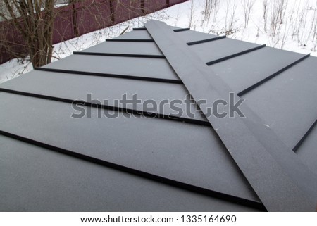 new grey folded metal roof of modern cottage viewed from above