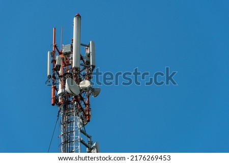 New GSM antennas on a high tower against a blue sky for transmitting a 5g signal are dangerous to health. Radiation pollution of the environment through cell towers. The threat of extinction