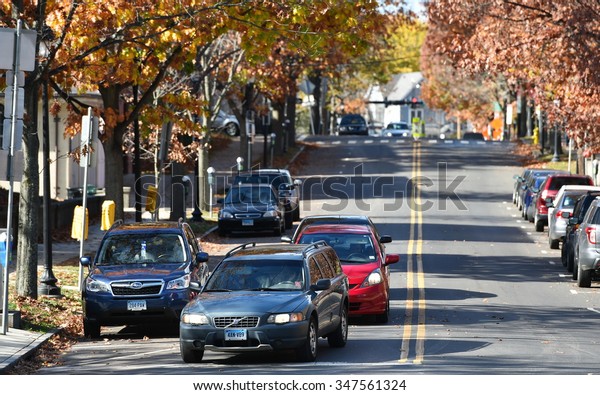 NEW HAVEN - NOV 14: Cars drive on a leafy\
city road on Nov 14, 2015 in New Haven,\
USA.