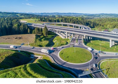 New highway in Poland on national road no 7, E77, called Zakopianka.  Overpass junction with a traffic circle, viaducts, slip roads, cars near Skomielna Biala. Aerial view. Far view of Tatra Mountains
