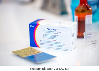 New Hill, North Carolina, USA: May 14th 2022; A packet of the Covid antiviral treatment and blister pack Paxlovid sitting on a home bathroom counter surrounded by other medicines.
