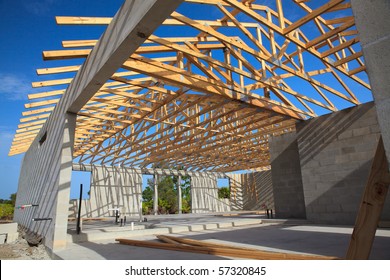 New home Construction of a cement block home with wooden roof trusses view from outside looking in. - Shutterstock ID 57320845
