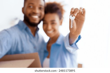 New Home. Happy Afro Couple Showing Keys Embracing After Moving In Own House Standing Indoor. Selective Focus, Shallow Depth - Powered by Shutterstock