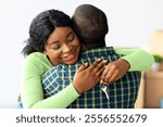 New Home. Happy black wife holding house keys and hugging husband, excited african american woman enjoying moving to new apartment together, cheerful spouses celebrating relocation, closeup