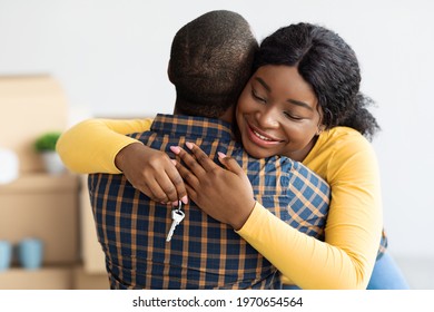 New Home. Happy Black Wife Holding House Keys And Hugging Husband, Excited African American Woman Enjoying Moving To New Apartment Together, Cheerful Spouses Celebrating Relocation, Closeup