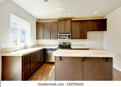 New Home Kitchen Interior With Dark Brown Cabinets And Hardwood Floors.