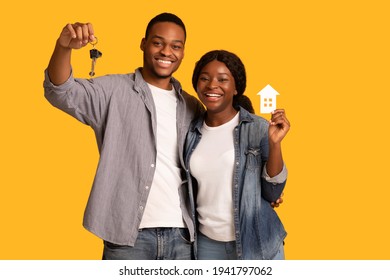 New Home Owners. Happy African American Couple Holding Paper House And Keys