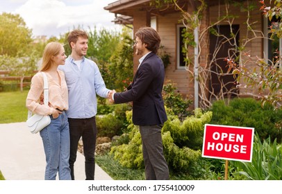 New Home Owners Shaking Hands With Their Real Estate Agent Near Residential Building Outside, Copy Space