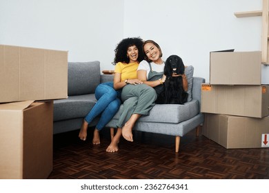 New home, portrait and lesbian couple with a dog on the sofa for moving boxes and relocation. Smile, lgbt and women or people on the living room couch of an apartment with a pet and a homeowner - Powered by Shutterstock