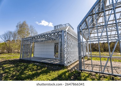 New home under construction using steel frames against cloudy sky. Metal frame of a new modern house. No people. Copy space.
