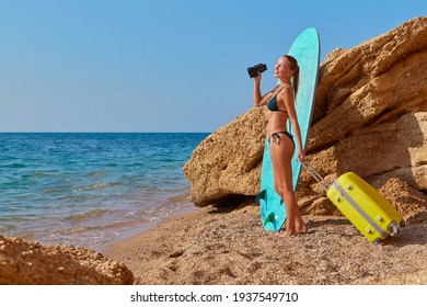 New Horizons, New Life And Future Concept. Cute Woman With Suitcase On Seashore. Girl Looking Away Through Binoculars.