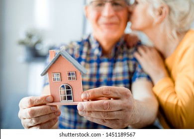 New House Concept, Happy Senior Couple Holding Small Home Model