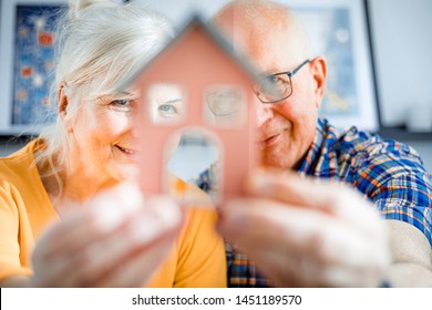 New House Concept, Happy Senior Couple Holding Small Home Model