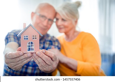 New House Concept, Happy Senior Couple Holding Small Home Model