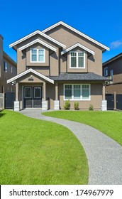 New House With Concrete Pathway Over Front Yard Lawn. Small Family House In Vancouver, British Columbia.