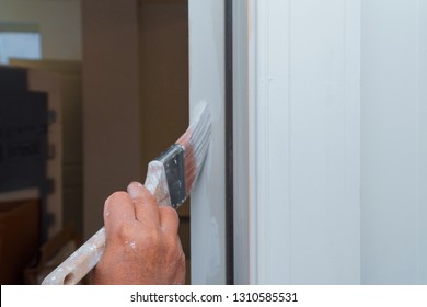 A New House Painter Painting The Door White In Door Frame