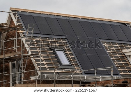 New house under construction with solar panels already installed on the roof