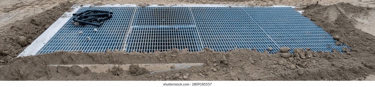 New housing development project, large underground stormwater catch basin vault with steel grate for access, stormwater management in a municipal infrastructure project
