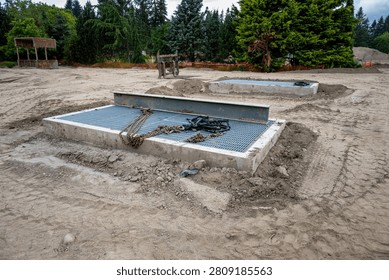 New housing development project, large underground stormwater catch basin vault with steel grate for access, stormwater management in a municipal infrastructure project
