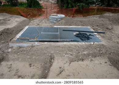 New housing development project, large underground stormwater catch basin vault with steel grate for access, stormwater management in a municipal infrastructure project
