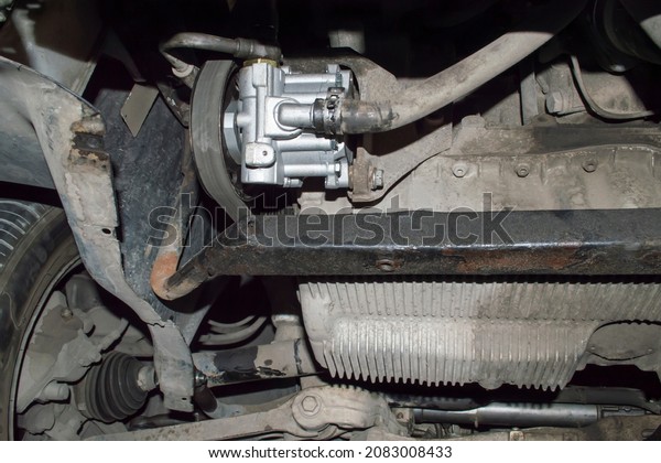 A new hydraulic power steering pump installed\
on a car in an auto repair\
shop