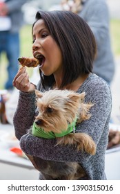 NEW IBERIA, L.A. / USA - FEBRUARY 28, 2015: A Side Profile Of A Cambodian, Kampuchean Woman Eating A Jalapeño Popper At A Birthday Party In South Louisiana. Adult Female Consuming Food At An Event.