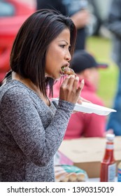 NEW IBERIA, L.A. / USA - FEBRUARY 28, 2015: A Side Profile Of A Cambodian, Kampuchean Woman Eating A Jalapeño Popper At A Birthday Party In South Louisiana. Adult Female Consuming Food At An Event.