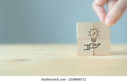 New idea, solution, suggestion concept.  Hand puts the wooden cubes with light bulb on hand icon on beuatiful grey background and copy space. Business review, strategy suggestion for business growth. - Shutterstock ID 2104868711