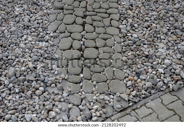 new\
infiltration parking lot made of aerated concrete tiles in a\
regular grid with holes filled with pebbles. sidewalk with\
interlocking paving, pattern of boulders,\
pebble