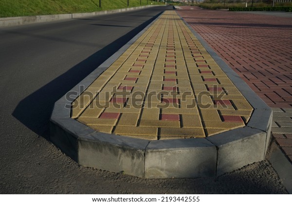 new\
infiltration parking lot made of concrete tiles in a square \
filled. in connection with the asphalt road and the sidewalk with\
paving. Empty bike and walking path near\
road.