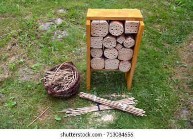 New Insect hotel  and reeds in basket in garden on grass