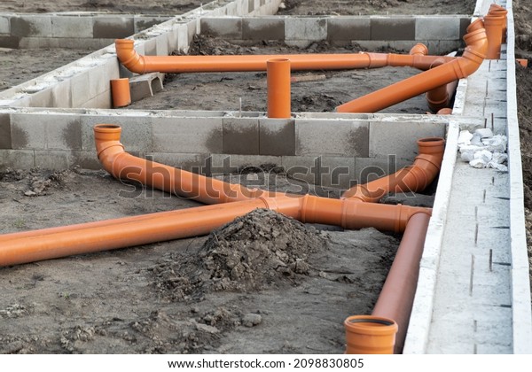 New Installed pipework system. Sewer Line developed\
and mounted on the construction site. New Orange PVC plastic\
Drainage pipe Tube