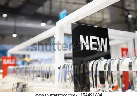NEW label on clothes rack in the woman clothing shop.