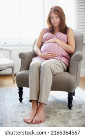 New Life Is A Beautiful Thing. A Glowing Pregnant Woman Looking At Her Swelling Baby Bump.