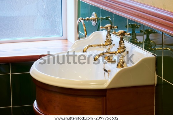 New luxury hotel vintage brass\
gold plated pillar taps in ensuite bathroom at wash\
basin