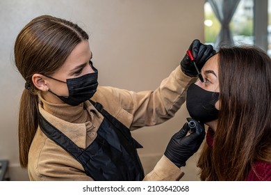 A New Make-up Artist Invited A Young Client In A Special Mask For Make-up During A Pandemic. The Concept Of Salons During A Pandemic