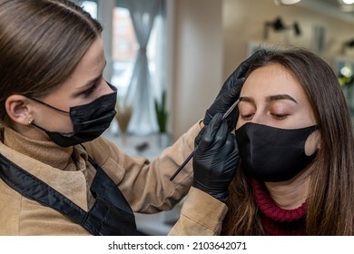 A New Make-up Artist Invited A Young Client In A Special Mask For Make-up During A Pandemic. The Concept Of Salons During A Pandemic