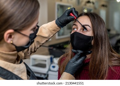 A New Make-up Artist Invited A Young Client In A Special Mask For Make-up During A Pandemic. The Concept Of Salons During A Pandemic