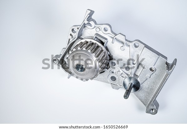 New metal automobile pump for cooling the engine\
of a water pump on a gray background. The concept of new spare\
parts for the car engine