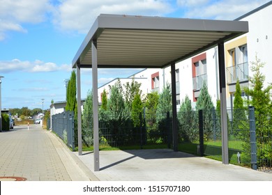 New Metal Carport with greened Roof in Front of a Multi Family residential Building