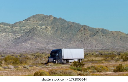 New Mexico NM USA - MARCH 14, 2020: Side View Of Bright Big Rig Semi Truck Fleet Transporting Cargo In Long Semi Trailer On The Flat Road In Mountain USA