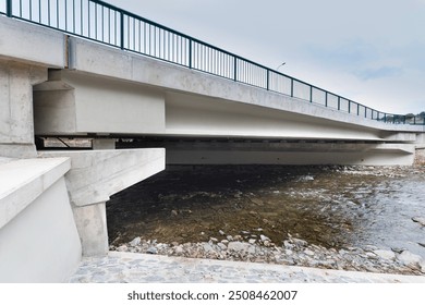 
A new modern automobile bridge over the river on the background of the blue sky. A sturdy reinforced concrete bridge, thick concrete pillars and metal floors. Aerial view - Powered by Shutterstock