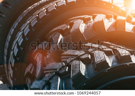 New modern black truck tire wheels in sunlight, close up